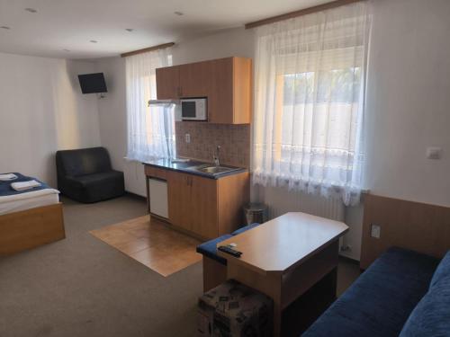 a small living room with a kitchen and a couch at Pension Euro in Mikulov
