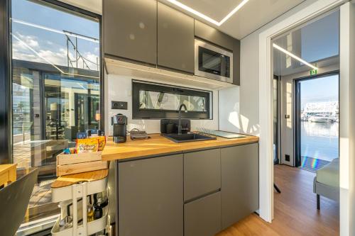 a kitchen with gray cabinets and a large window at The Homeboat Company Sant'Elmo-Cagliari in Cagliari