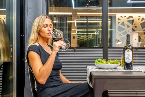 a woman sitting at a table drinking a glass of wine at The Homeboat Company Sant'Elmo-Cagliari in Cagliari