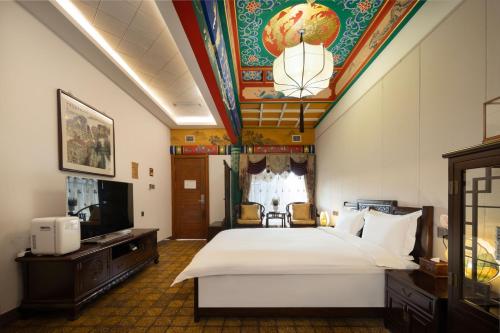 a hotel room with a large bed and a tv at Datong Yunzhong Traditional Courtyard in Datong