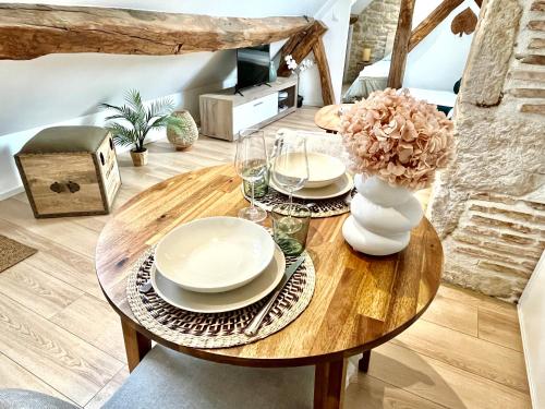 une table en bois avec des assiettes et un vase de fleurs. dans l'établissement le cité, à Dijon