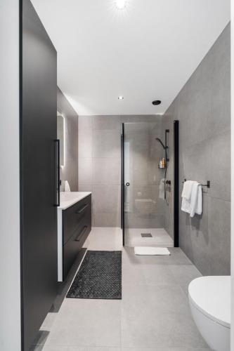 a bathroom with a shower and a sink and a toilet at Norse Horizon in Tau