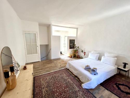 une chambre avec un lit blanc et un tapis dans l'établissement Lumineuse maison de centre-ville, à Arles