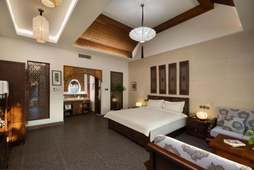 a bedroom with a large white bed and a couch at Datong Yunzhong Traditional Courtyard in Datong