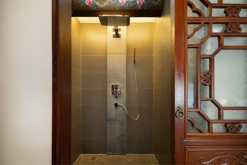 a bathroom with a shower with a glass door at Datong Yunzhong Traditional Courtyard in Datong