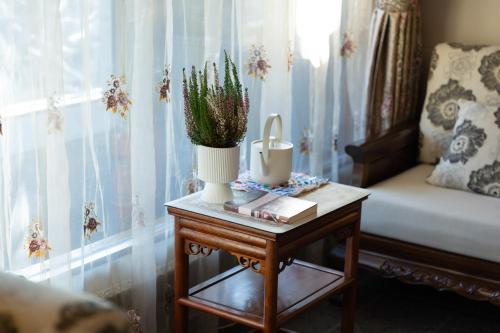 a table with a plant and a vase on it at Datong Yunzhong Traditional Courtyard in Datong