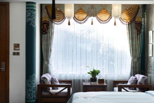 a bedroom with two beds and a large window at Datong Yunzhong Traditional Courtyard in Datong