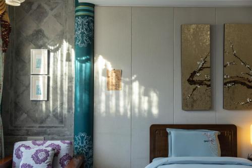 a bedroom with a bed and pictures on the wall at Datong Yunzhong Traditional Courtyard in Datong