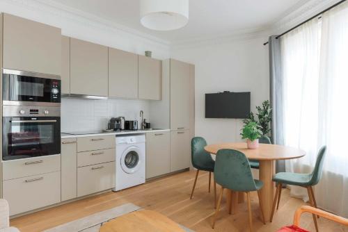 une cuisine avec une table et des chaises ainsi qu'une salle à manger dans l'établissement Proche Nation - Appartement à Paris 20e - Haystia, à Paris