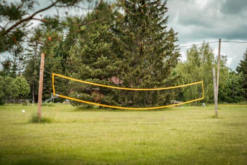 a volley ball net in a field with a tree at Saarelux Riverise Villa in Mõraste