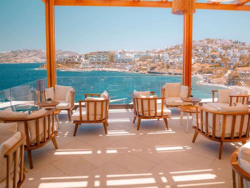 a room with chairs and tables and a large window at The Bodrum Hotel Yalikavak - MGallery Collection in Yalıkavak