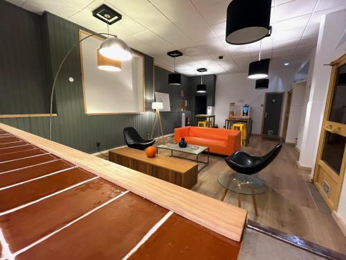 a living room with an orange couch and chairs at The Orange Teddy Bear Hostal La Peña in Mieres