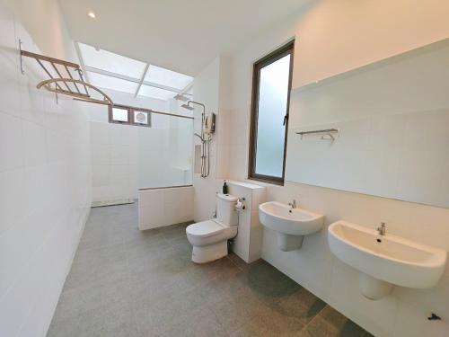 a white bathroom with a sink and a toilet at 2 Spacious Lupsxury conor villa garden Parking group family gathering wedding in Gelugor