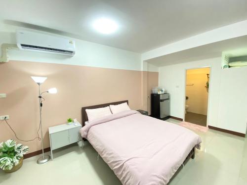a bedroom with a bed and a air conditioner at La Maison 230 in Ban Khlong Samrong