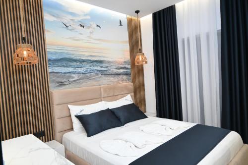 a bedroom with a bed with a picture of the ocean at Vila La Familia in Ksamil