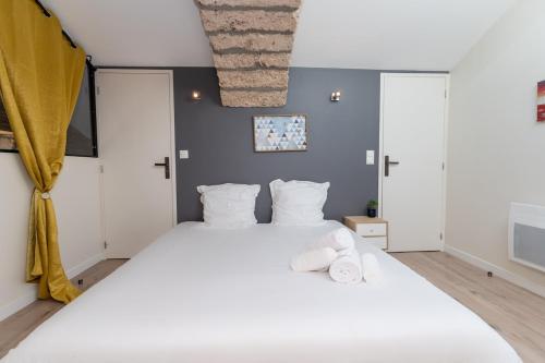 - une chambre avec un grand lit blanc et des oreillers blancs dans l'établissement Le mas de Egines, à Saint-Rome-de-Cernon