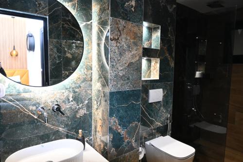 a bathroom with a toilet and a mirror at Vila La Familia in Ksamil