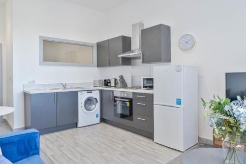 una cocina con refrigerador y lavadora y secadora en Modern & Cosy 1 Bedroom Budget Apartment in Dudley, en Brierley Hill