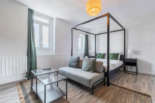 une chambre avec un lit, un canapé et un miroir dans l'établissement Vieux Lille - Studio calme idéalement situé !, à Lille