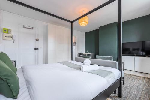 une chambre avec un grand lit blanc dans une pièce dans l'établissement Vieux Lille - Studio calme idéalement situé !, à Lille