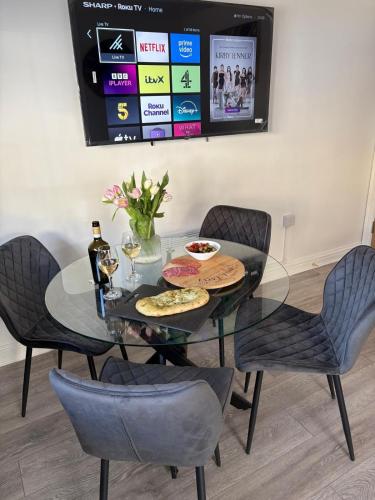 a dining room table with chairs and a television at Apartment 1 The Baileys Cwm 2 Bedroom Sleeps 4 in Cwm