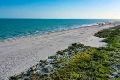 an overhead view of a beach with people in the water at Sandpiper Beach #405 in Sanibel