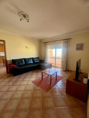 a living room with a black couch and a table at Apart. Arco-Iris - Amazing view in Lagos