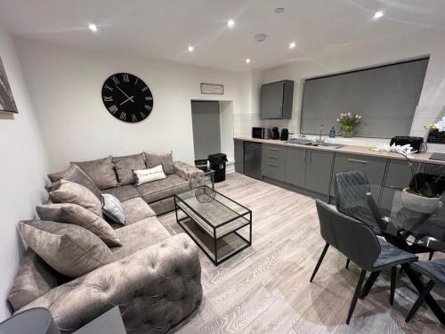 a living room with a couch and a clock on the wall at Apartment 1 The Baileys Cwm 2 Bedroom Sleeps 4 in Cwm