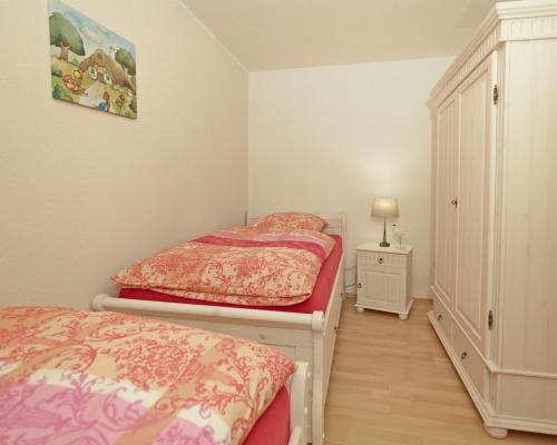1 Schlafzimmer mit 2 Einzelbetten und einem Schrank in der Unterkunft Ferienwohnung in Otterndorf in Otterndorf