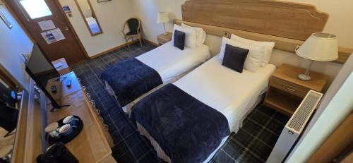 a hotel room with two beds and a lamp at The Red Lion Tavern in Fochabers
