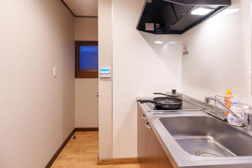 Y's INN 渋谷本町 019T في طوكيو: مطبخ مع حوض وموقد