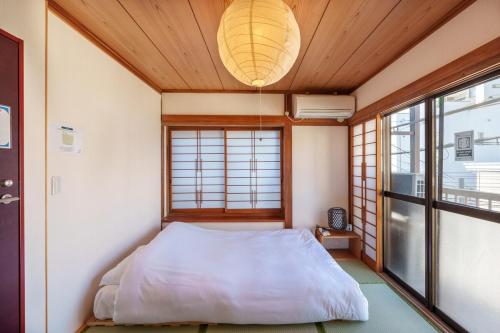 Y's INN 渋谷本町 019T في طوكيو: غرفة نوم بها سرير ونافذة كبيرة