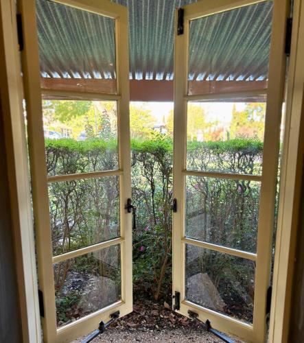 an open window with a view of a garden at Goat Square House - Historic Row Cottages in Tanunda