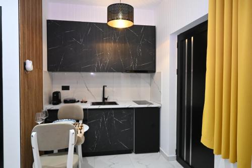 a kitchen with black and white counters and a sink at Vila La Familia in Ksamil