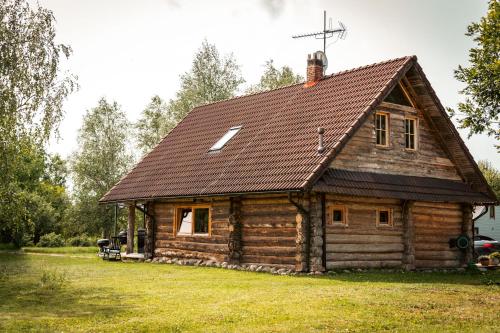 a log cabin with a cross on the roof at Saarelux Riverise Villa in Mõraste