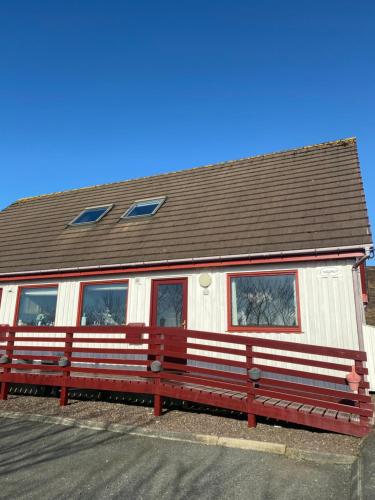 a red bench in front of a house at Apartment 1, Craigmore in Lerwick