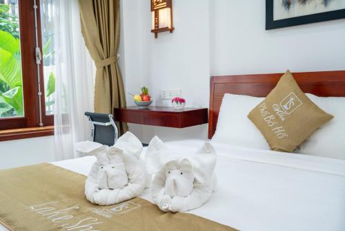 two towels are sitting on top of a bed at Villa Lake Shore Hoi An in An Bang
