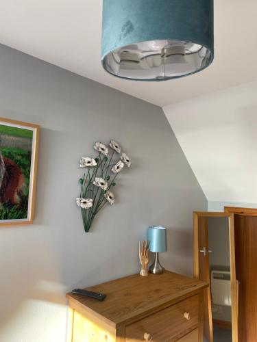 a room with a table with a vase of flowers on the wall at Apartment 1, Craigmore in Lerwick