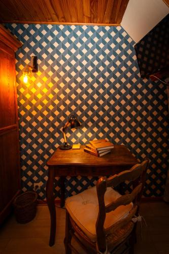 une chambre avec une table et une lampe sur un mur dans l'établissement Auberge du Blaisel, à Wirwignes