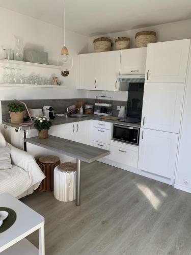 une cuisine avec des armoires blanches et une table dans l'établissement Charmant T2 a 500 m du port avec parking privé, à Sanary-sur-Mer
