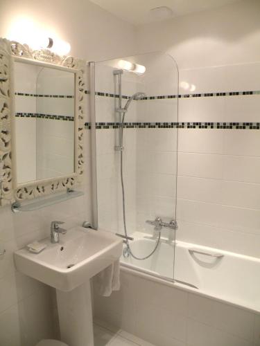 a bathroom with a sink and a shower and a tub at Hôtel Diderot in Chinon