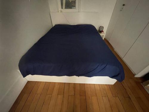 Ce lit se trouve dans une petite chambre dotée de parquet. dans l'établissement Charmant appartement Marais, à Paris