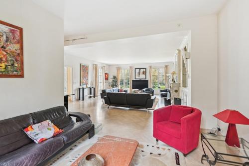 - un salon avec un canapé et un fauteuil rouge dans l'établissement La Maison des Rois, à Rueil-Malmaison