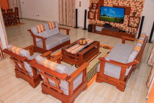 a living room filled with furniture and a flat screen tv at ODG Cotonou - Résidences Océan De Grâce in Cotonou
