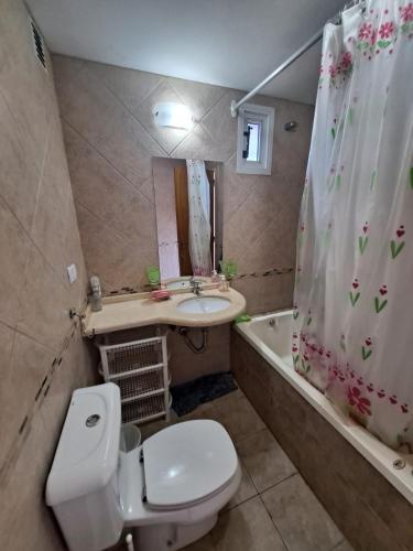 a bathroom with a toilet and a sink and a tub at Departamento España in Rosario