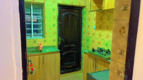a bathroom with a black door and a sink at JMC House in Ibadan