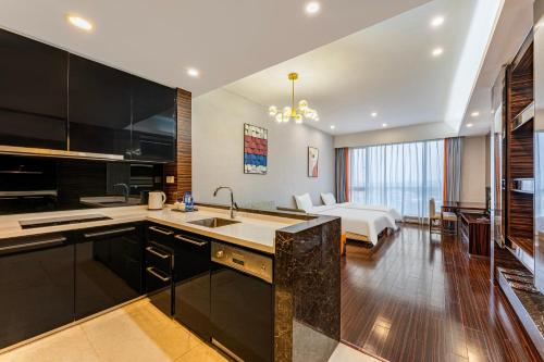 a kitchen with a sink and a living room with a bed at eStay Residence·Poly World Trade Center Guangzhou in Guangzhou
