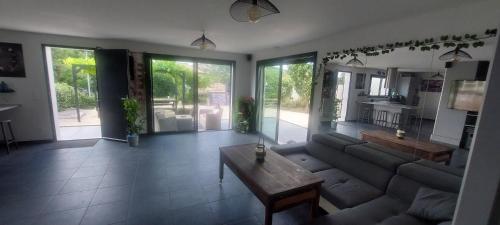 un salon avec un canapé et une table dans l'établissement Single-story villa with pool and outdoor playground, à Saint-Paul-et-Valmalle