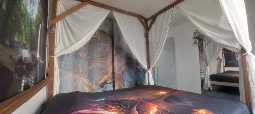 - une chambre avec un lit à baldaquin et un tableau dans l'établissement Single-story villa with pool and outdoor playground, à Saint-Paul-et-Valmalle