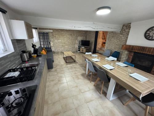 une cuisine et un salon avec une table et des chaises dans l'établissement La Maison du Chapron - Jaunay Marigny - Futuroscope, à Jaunay-Clan